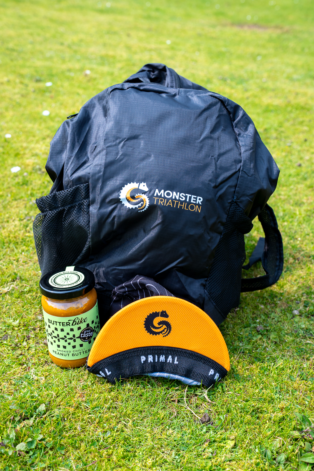 A Monster Triathlon backpack, food jar and orange cycling cap