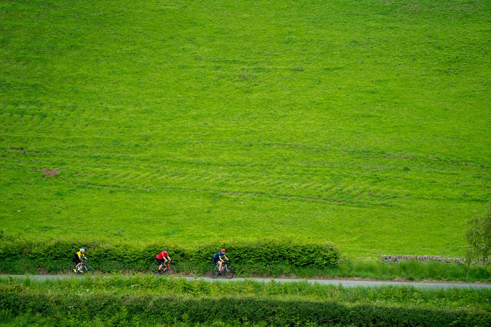 Riders small against open English farmland